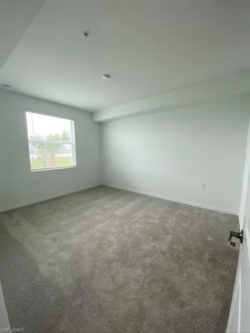 Carpeted spare room with baseboards