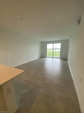 Spare room with light tile patterned flooring and baseboards