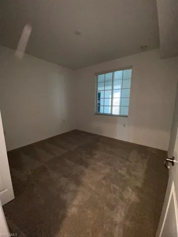 Spare room featuring dark carpet