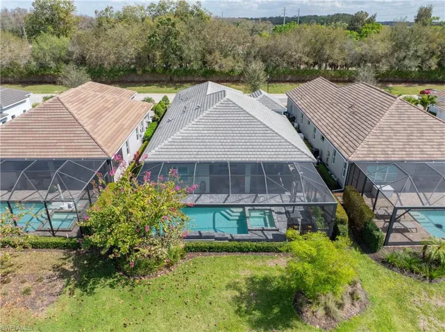 Bird's eye view of a tree filled landscape and a pool