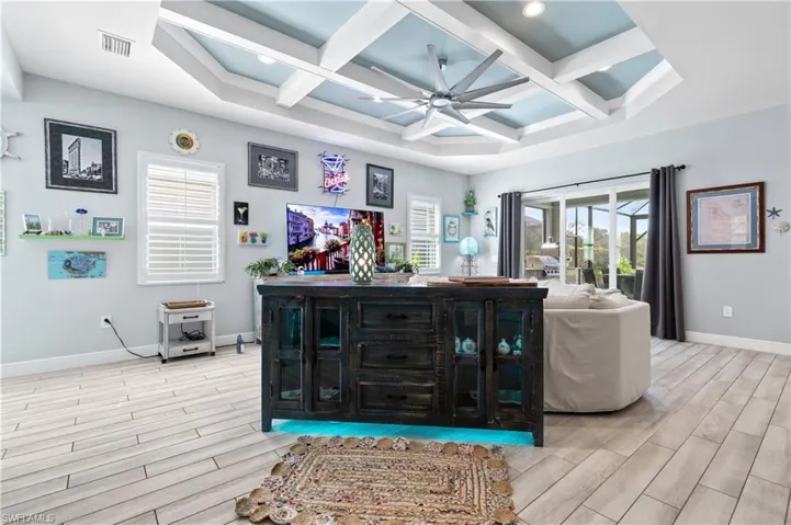 Living area featuring wood tiled floors, coffered ceiling, ceiling fan, and recessed lighting