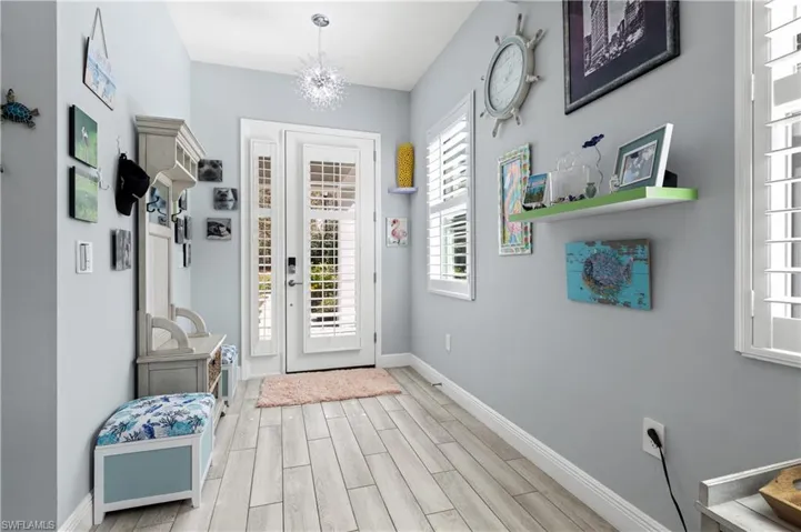 Entrance foyer with wood tiled floors and hanging lights