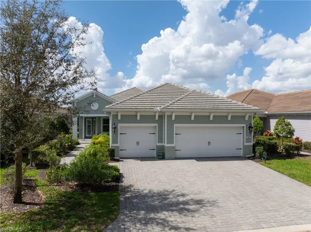 View of front of home with a tiled roof, a garage, and decorative driveway