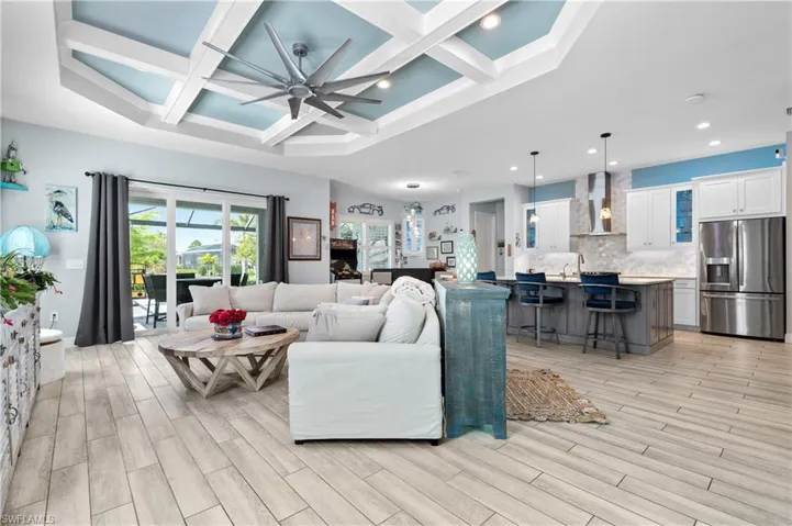 Living area featuring coffered ceiling, ceiling fan, wood tiled floors, and recessed lighting