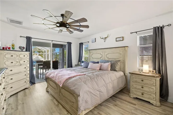 Bedroom featuring multiple windows, access to exterior, light wood finished floors, and visible vents