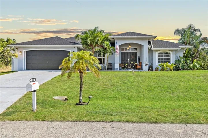 Virtual Photo Ranch-style house with an attached garage, driveway, stucco siding, and a front yard