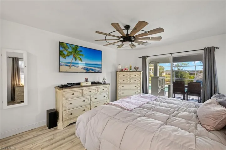 Bedroom featuring baseboards, ceiling fan, light wood-style flooring, and access to exterior