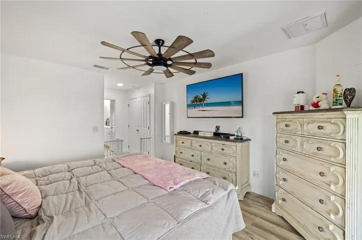 Bedroom with visible vents, light wood finished floors, ceiling fan, and baseboards