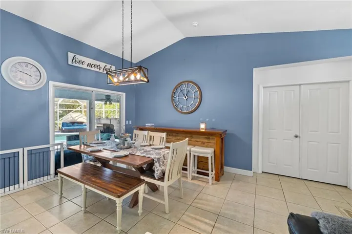 Dining room featuring high vaulted ceiling, tile patterned flooring, baseboards, and a chandelier