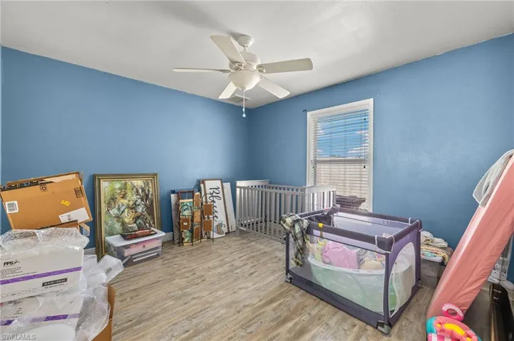Guet Bedroom with wood finished floors and a ceiling fan