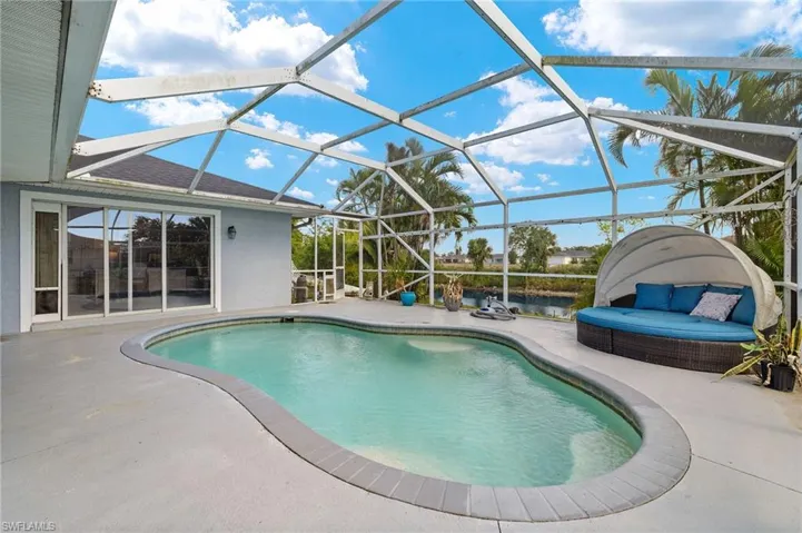 Outdoor pool with a water view, a lanai, and a patio area
