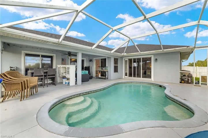 View of pool with ceiling fan, outdoor dining area, glass enclosure, a fenced in pool, and a patio
