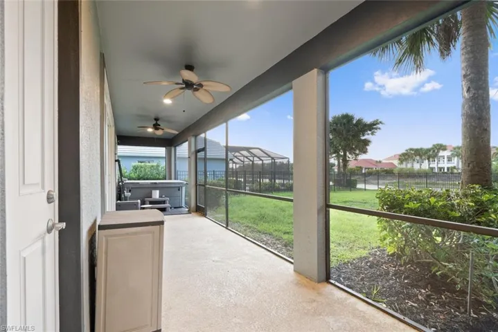 Unfurnished sunroom with a hot tub and a residential view