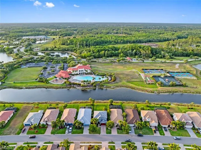 View of property location with a nearby body of water, a forest, and nearby suburban area