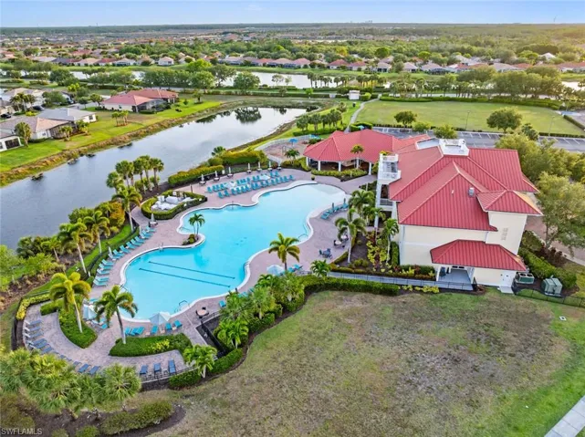 Aerial view of residential area with a large body of water and a pool area