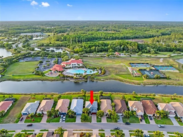 Aerial view of property's location with a nearby body of water, a forest, and nearby suburban area