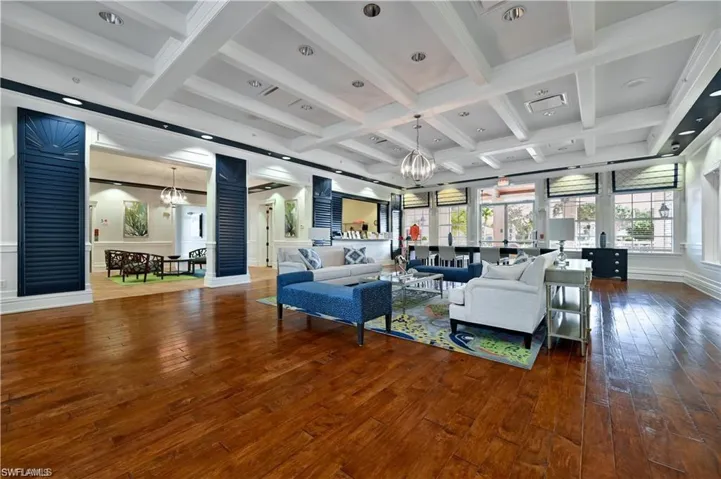 Living area with a chandelier, beam ceiling, wood-type flooring, coffered ceiling, and plenty of natural light