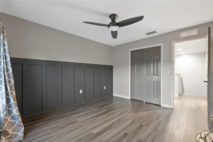 Unfurnished bedroom with wood finished floors, ceiling fan, and a closet