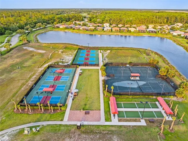 Aerial view of residential area with a nearby body of water and a heavily wooded area