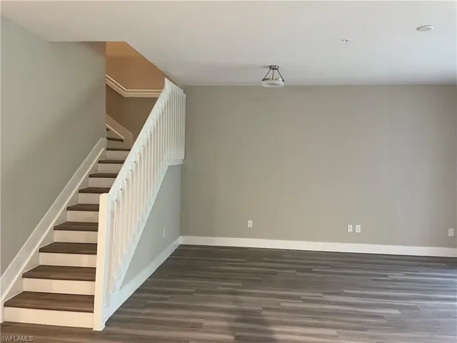 Staircase featuring vinyl finished floors and baseboards