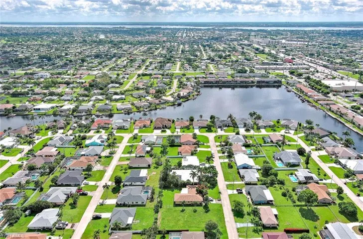 Aerial view of residential area featuring a nearby body of water