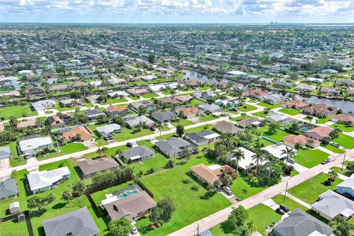 Aerial view of property and surrounding area featuring nearby suburban area and a nearby body of water