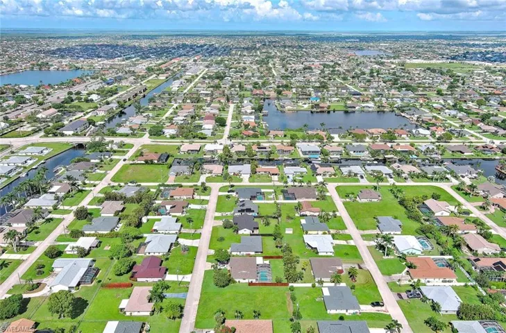 Aerial view of property's location with a nearby body of water and nearby suburban area