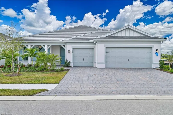 Ranch-style home featuring a garage, decorative driveway, a tile roof, and stucco siding