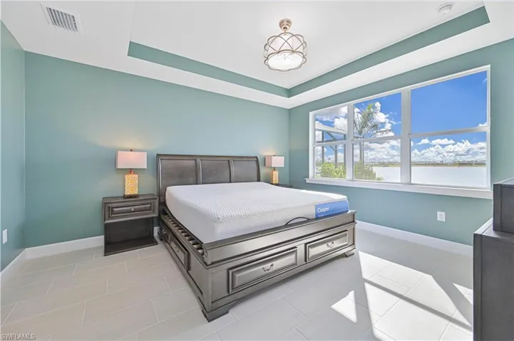 Bedroom with a raised ceiling and tile patterned flooring