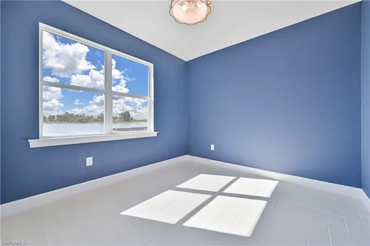 Empty room with baseboards and a water view