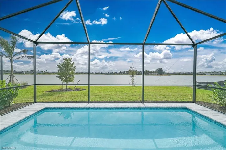 Swimming pool featuring a sunroom, glass enclosure, and a yard