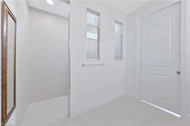 Full bath with a walk in shower and baseboards