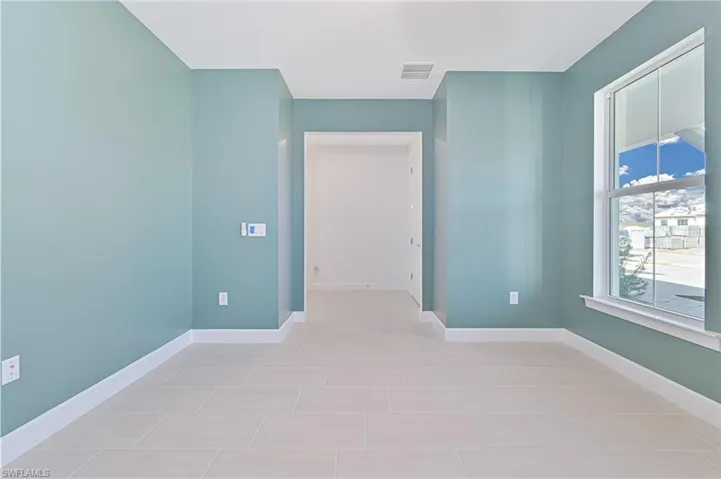 Empty room featuring baseboards and light tile patterned floors