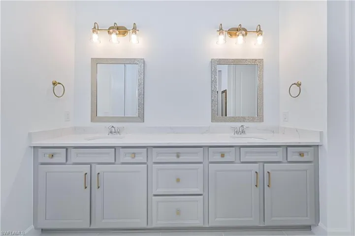 Bathroom featuring baseboards and double vanity
