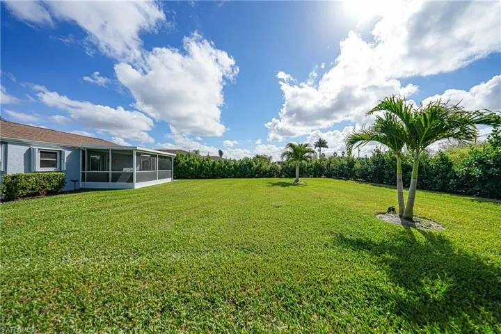 View of grassy yard with a sunroom