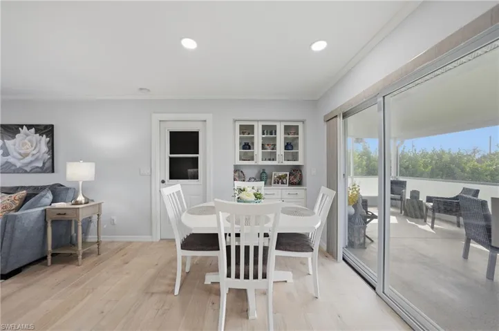 Dining space with crown molding, light wood finished floors, and recessed lighting