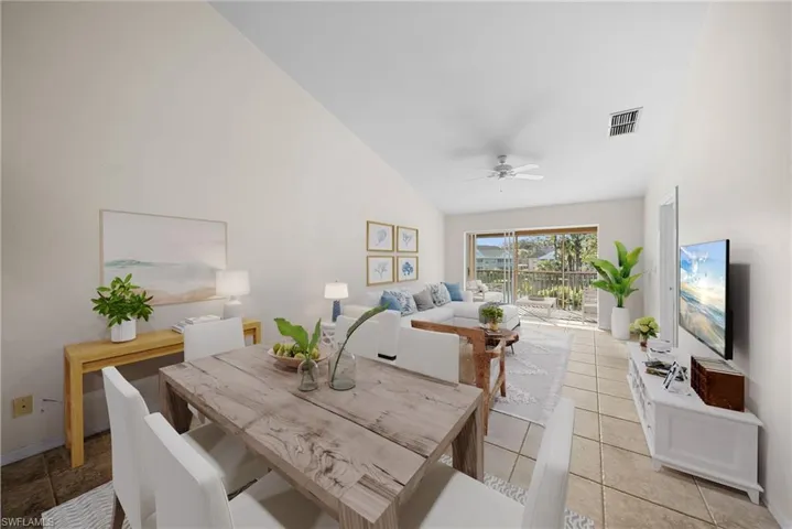 Dining space featuring ceiling fan, high vaulted ceiling, and tile patterned floors