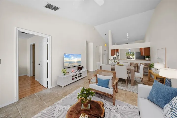 Living area with high vaulted ceiling and ceiling fan