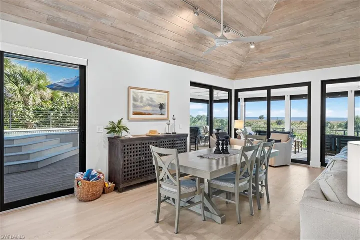 Dining room with wood ceiling, light wood-style floors, lofted ceiling, a ceiling fan, and track lighting