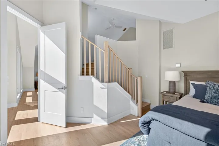 Bedroom featuring wood finished floors and high vaulted ceiling