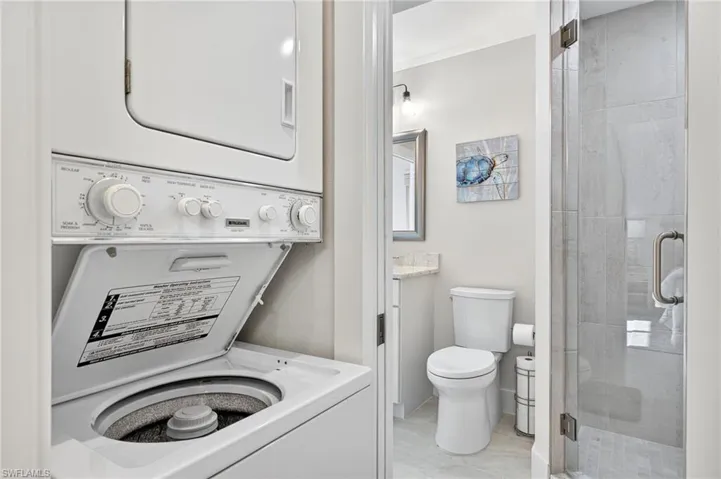 Laundry area featuring stacked washing machine and dryer
