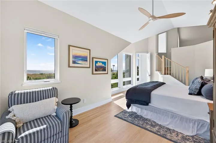 Bedroom featuring wood finished floors, a ceiling fan, and lofted ceiling