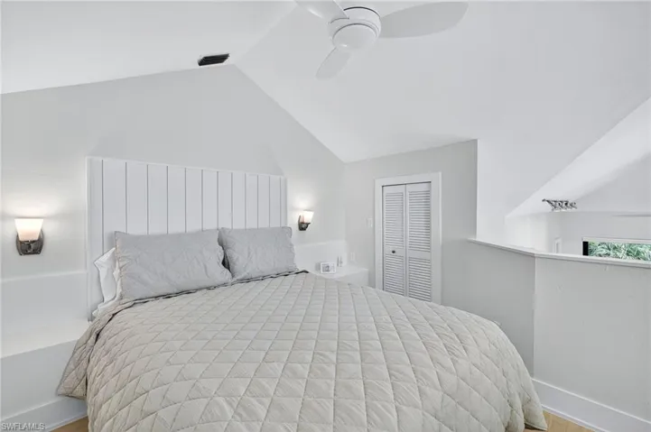 Bedroom with a closet, vaulted ceiling, ceiling fan, and wood finished floors