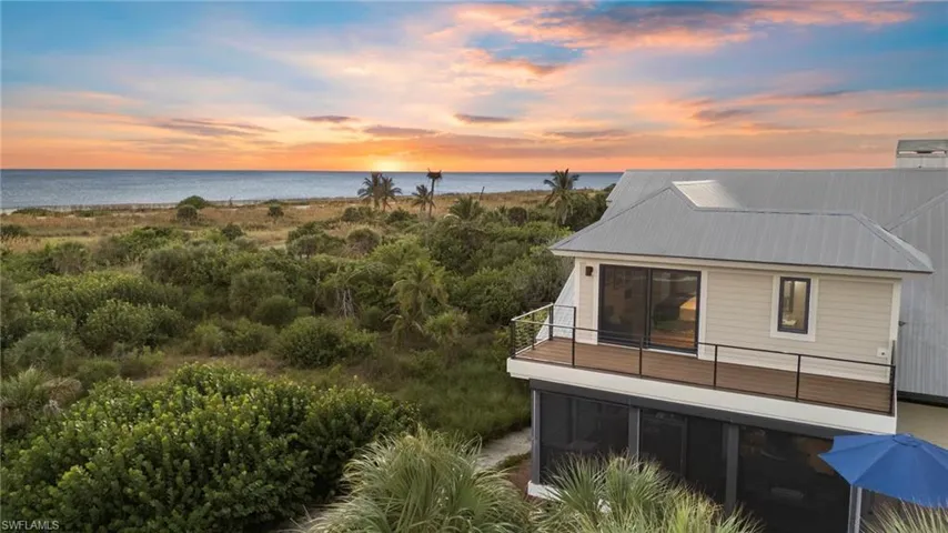 Rear view of house featuring a balcony and a water view