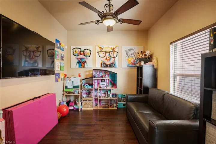 Rec room with dark wood-style floors and a ceiling fan
