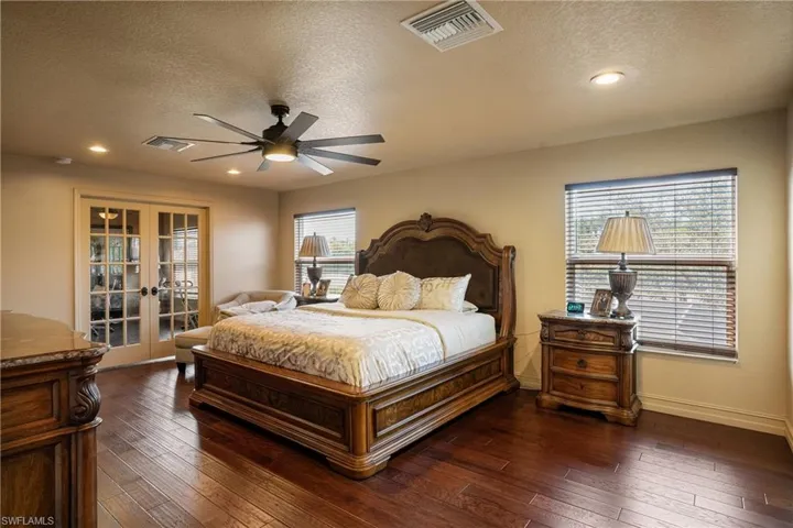 Bedroom featuring dark wood-style floors, french doors, and visible vents