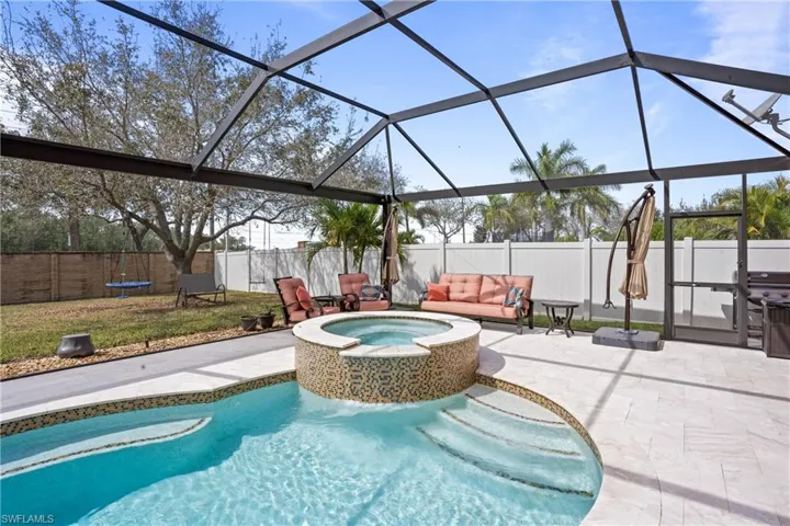 View of swimming pool featuring a patio, a fenced backyard, a lanai, an outdoor hot tub, and a fenced in pool