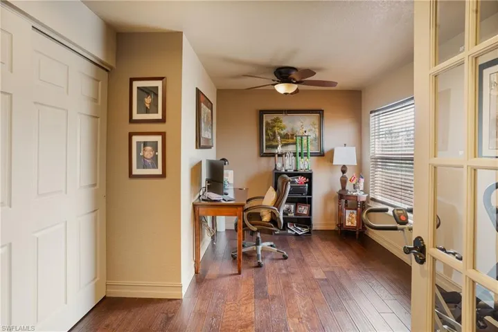 Office featuring dark wood-type flooring, ceiling fan, and baseboards