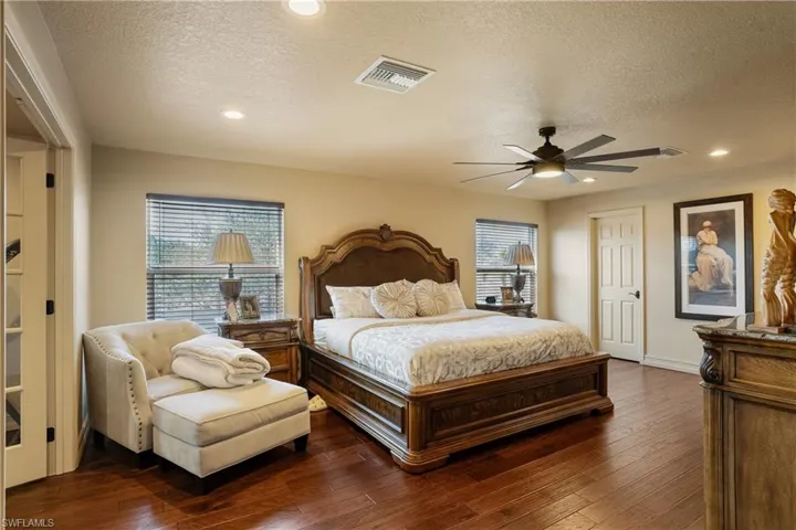 Bedroom with recessed lighting, dark wood-style flooring, visible vents, and a textured ceiling
