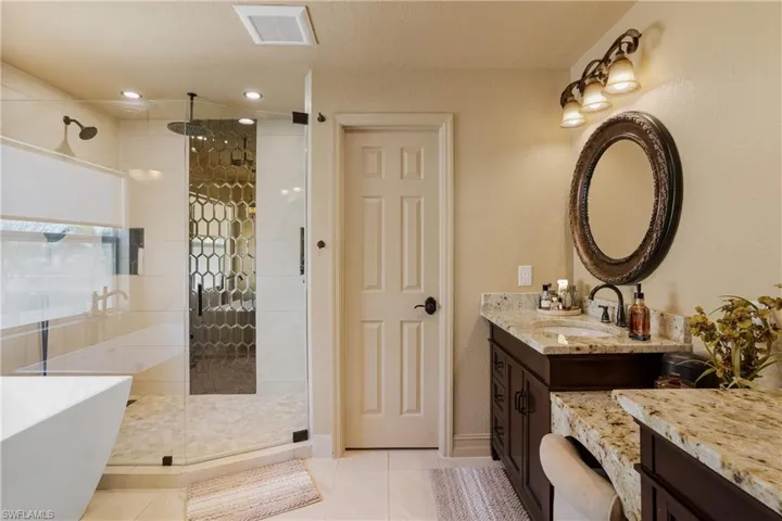 Full bathroom with a soaking tub, visible vents, a stall shower, vanity, and tile patterned flooring